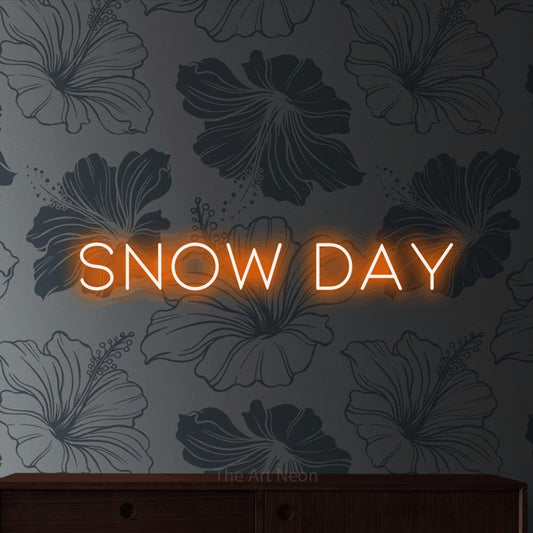 Orange LED neon sign reading "Snow Day" against grey floral wallpaper