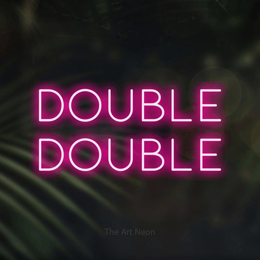 Enseigne néon à DEL à lumière rose vif, affichant « Double Double » sur des feuilles de palmier foncées et floues