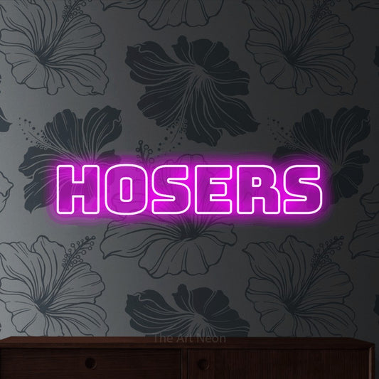 Enseigne néon à DEL à lumière rose, de style contour, affichant « Hosers » sur un papier peint floral gris
