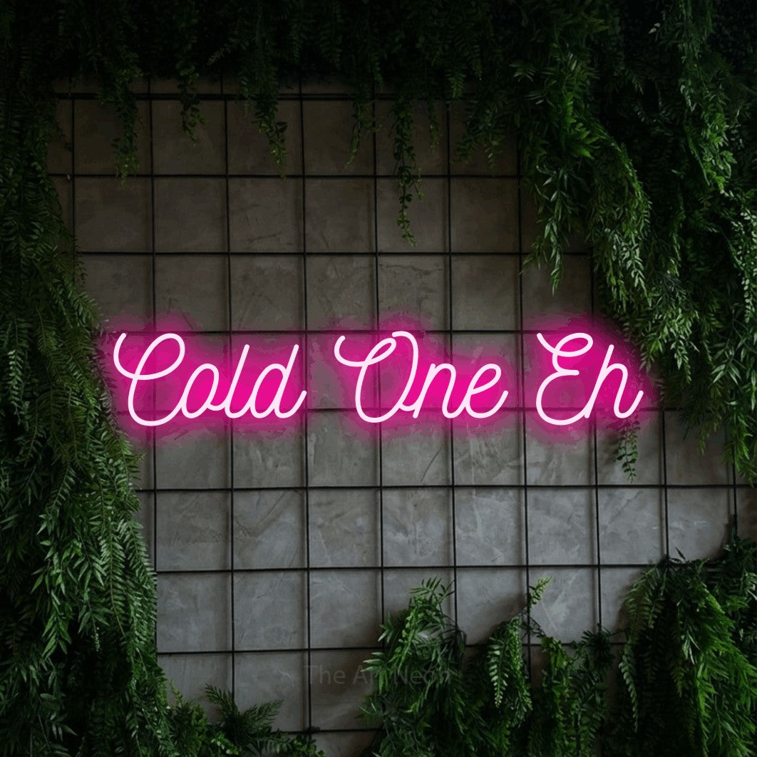 Enseigne néon à DEL à lumière rose vif, de style manuscrit, affichant « Cold One Eh » sur un mur quadrillé vert avec du feuillage