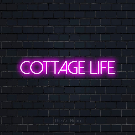 Pink LED neon sign reading "Cottage Life" against a dark navy brick wall