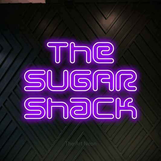 Purple outline-style LED neon sign reading "The Sugar Shack" against a dark geometric wood wall