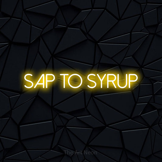 Yellow LED neon sign reading "Sap to Syrup" against a black faceted wall