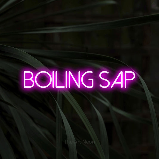 Pink LED neon sign reading "Boiling Sap" against dark tropical leaves