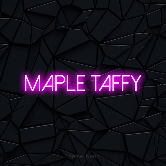 Pink LED neon sign reading "Maple Taffy" against a black faceted wall