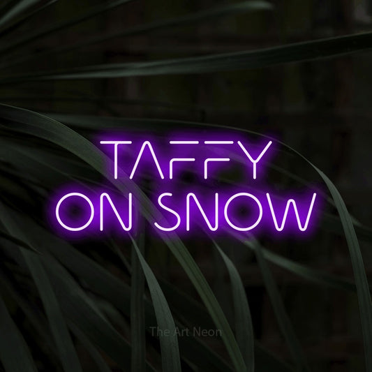 Purple LED neon sign reading "Taffy on Snow" against dark tropical leaves