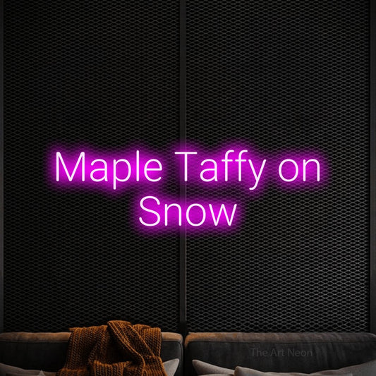 Pink LED neon sign reading "Maple Taffy on Snow" against a black textured wall