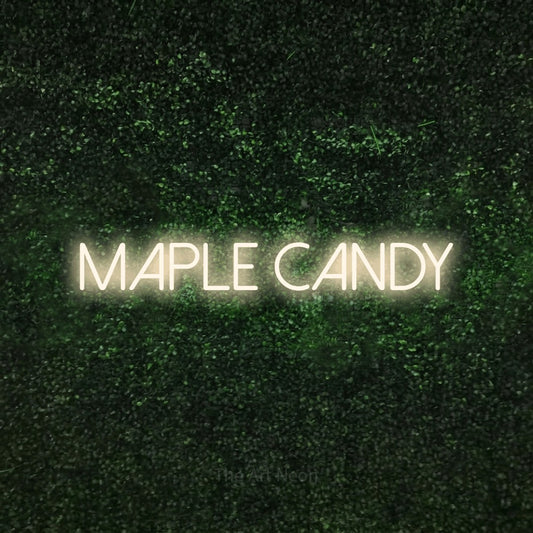 Warm white LED neon sign reading "Maple Candy" against a textured green moss wall