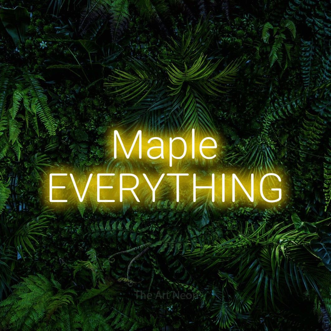 Yellow LED neon sign reading "Maple Everything" against a dense tropical foliage wall