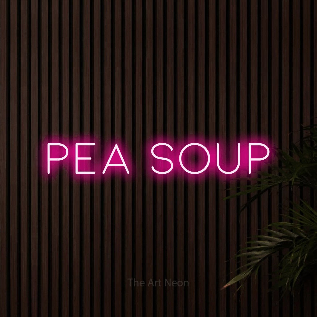 Hot pink LED neon sign reading "Pea Soup" against dark wooden slats