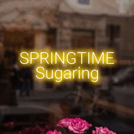 Yellow LED neon sign reading "Springtime Sugaring" in a softly blurred café interior