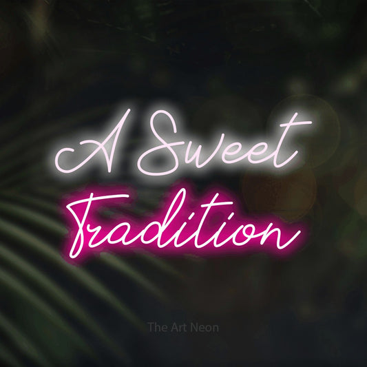 Hot pink and cool white script-style LED neon sign reading "A Sweet Tradition" against dark blurred palm leaves