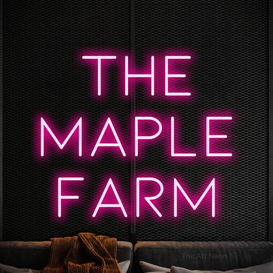 Hot pink LED neon sign reading "The Maple Farm" against a black textured wall