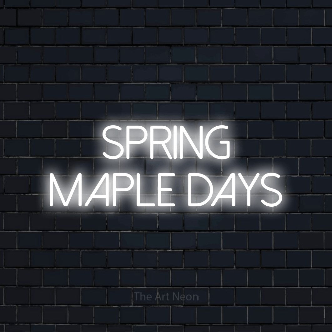 Cool white LED neon sign reading "Spring Maple Days" against a dark navy brick wall