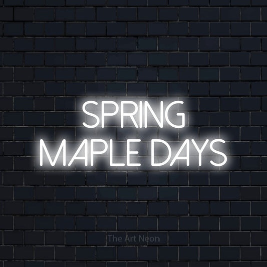 Cool white LED neon sign reading "Spring Maple Days" against a dark navy brick wall