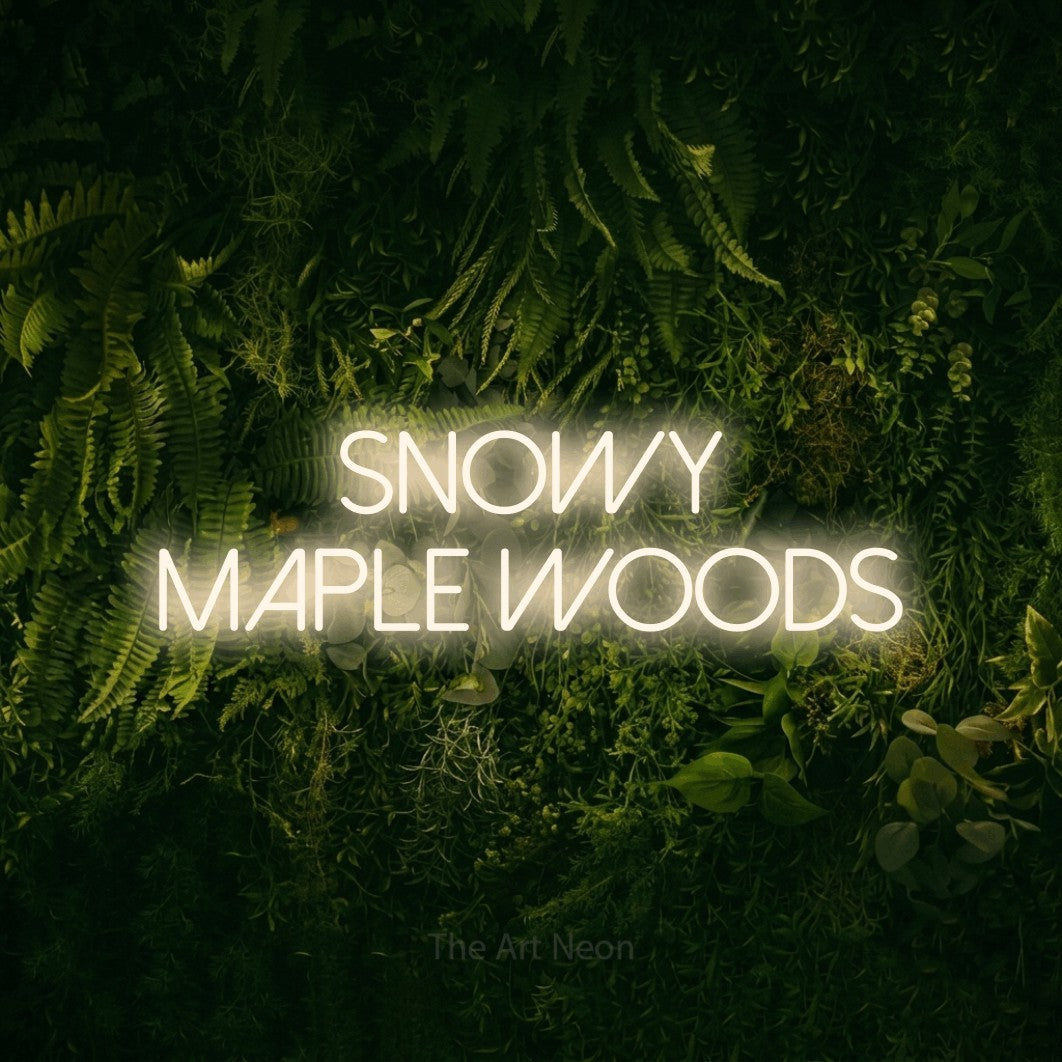 Warm white LED neon sign reading "Snowy Maple Woods" against a moss-covered green wall