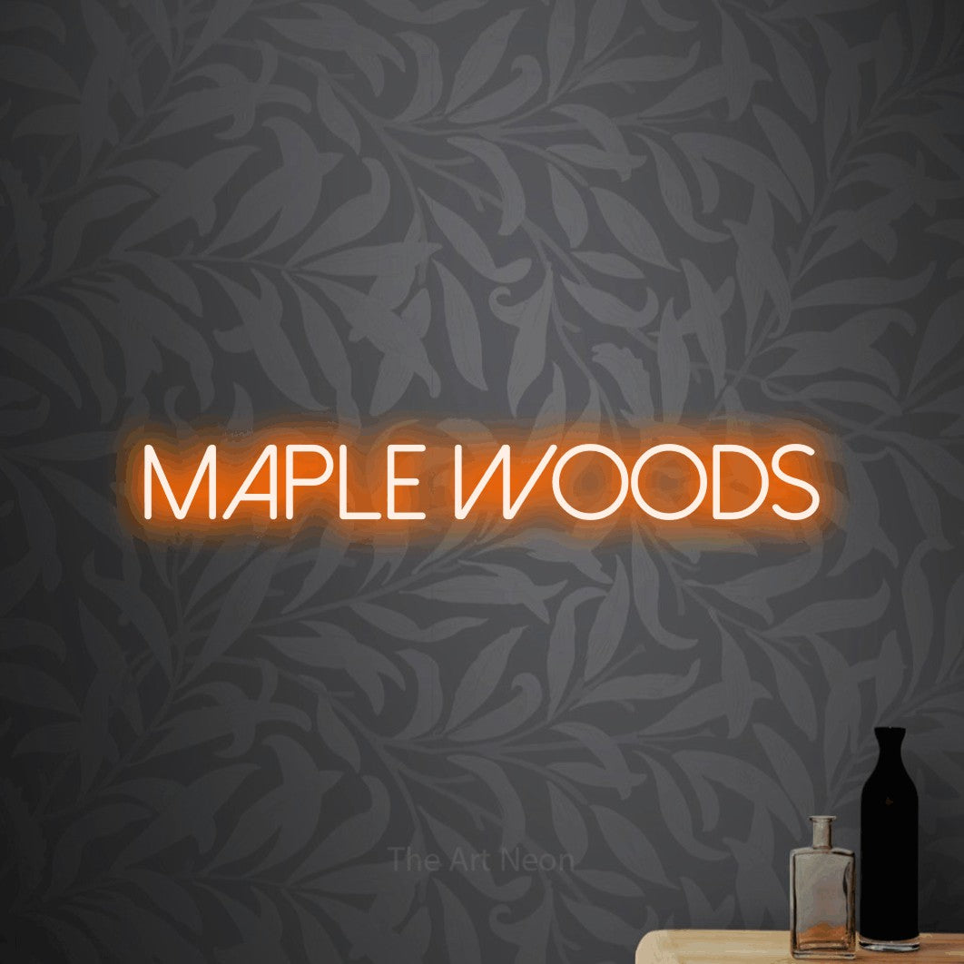 Orange LED neon sign reading "Maple Woods" against light grey floral wallpaper