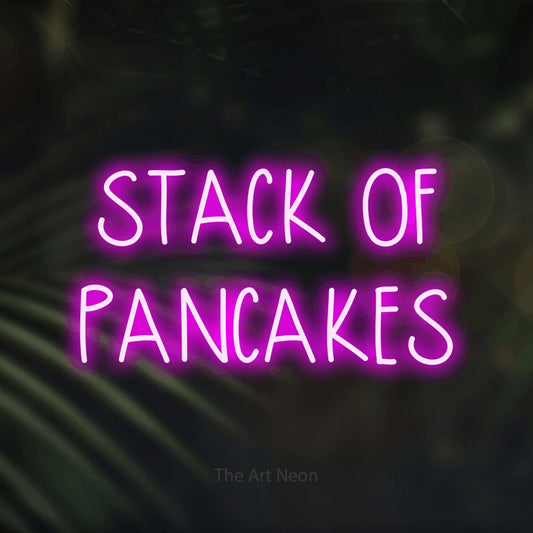 Pink LED neon sign reading "Stack of Pancakes" against dark blurred palm leaves