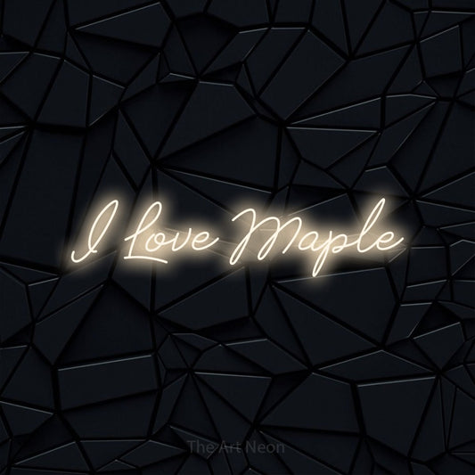 Warm white script-style LED neon sign reading "I Love Maple" against a black faceted wall