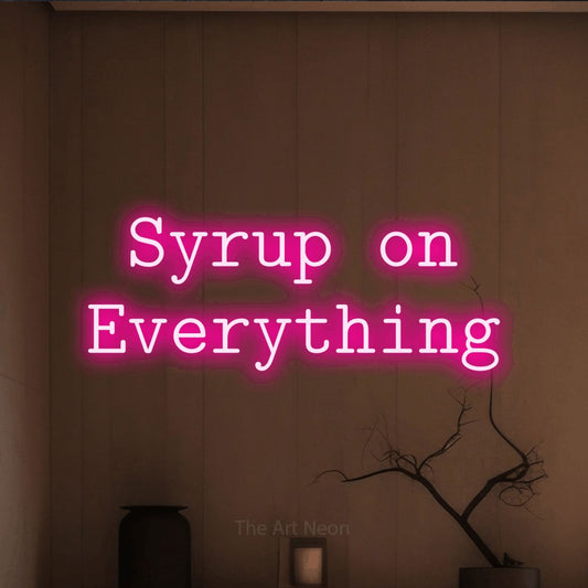 Hot pink LED neon sign reading "Syrup on Everything" against a warm brown wall