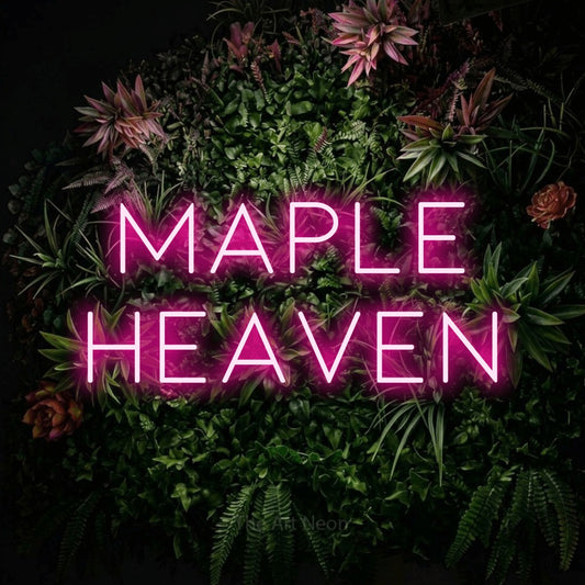 Hot pink LED neon sign reading "Maple Heaven" against a flowering garden wall