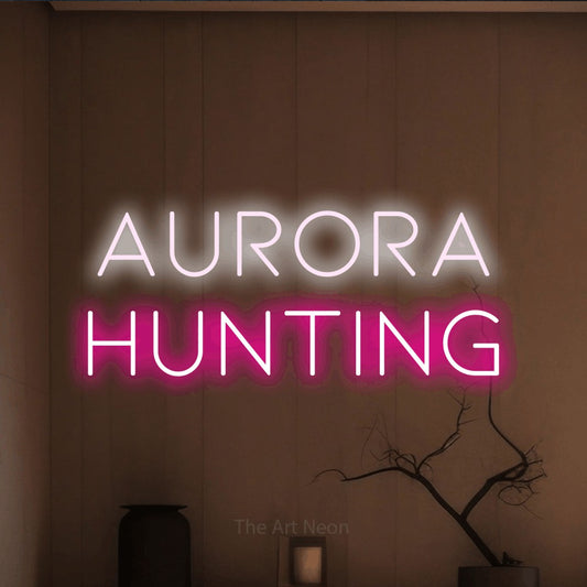 Hot pink and cool white LED neon sign reading "Aurora Hunting" against a warm brown wall