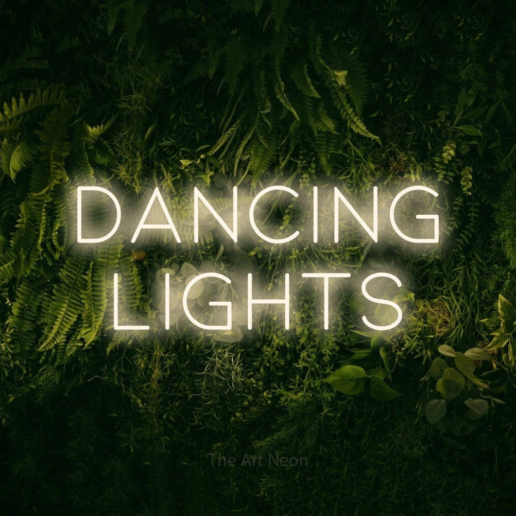 Warm white LED neon sign reading "Dancing Lights" against a moss-covered green wall