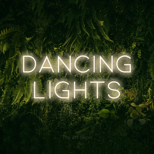 Warm white LED neon sign reading "Dancing Lights" against a moss-covered green wall
