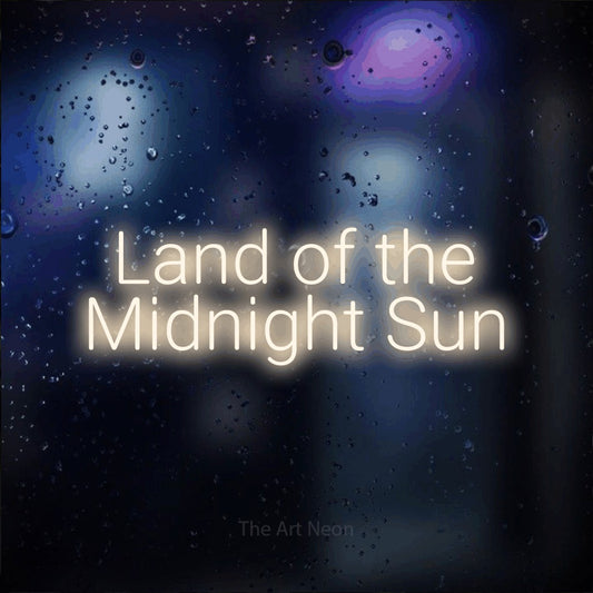 Warm white LED neon sign reading "Land of the Midnight Sun" against a dark blue bokeh background