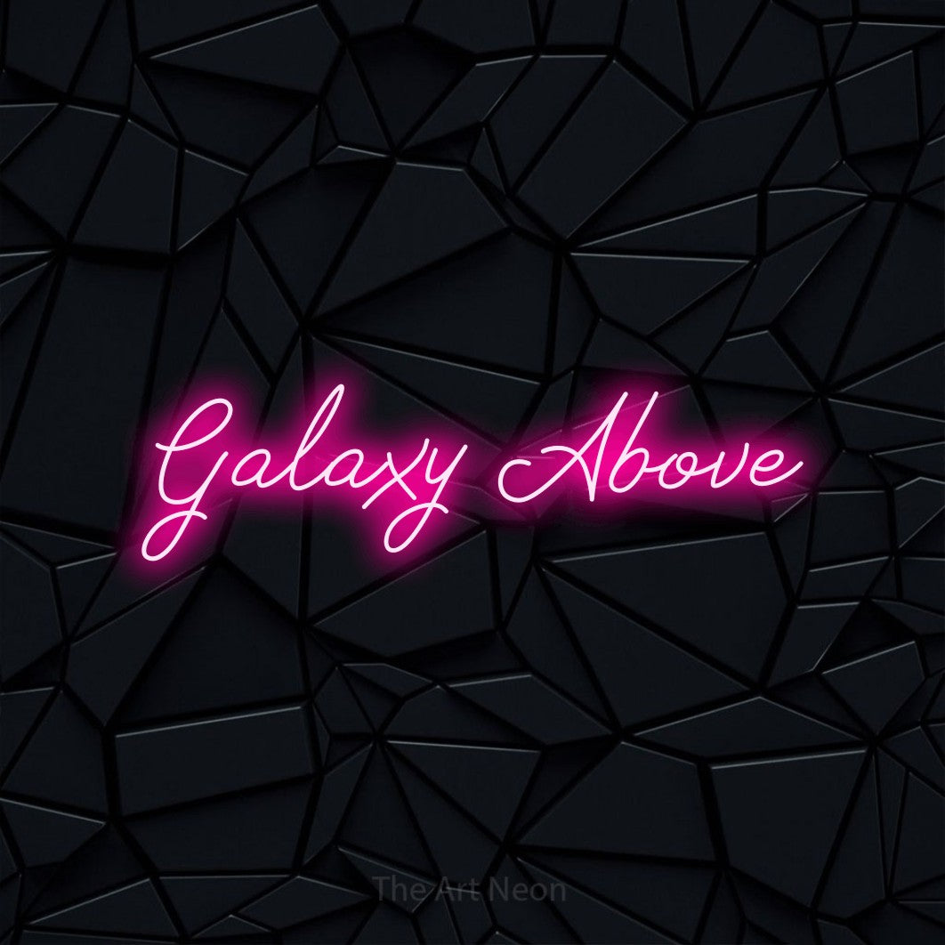 Hot pink script-style LED neon sign reading "Galaxy Above" against a black faceted wall