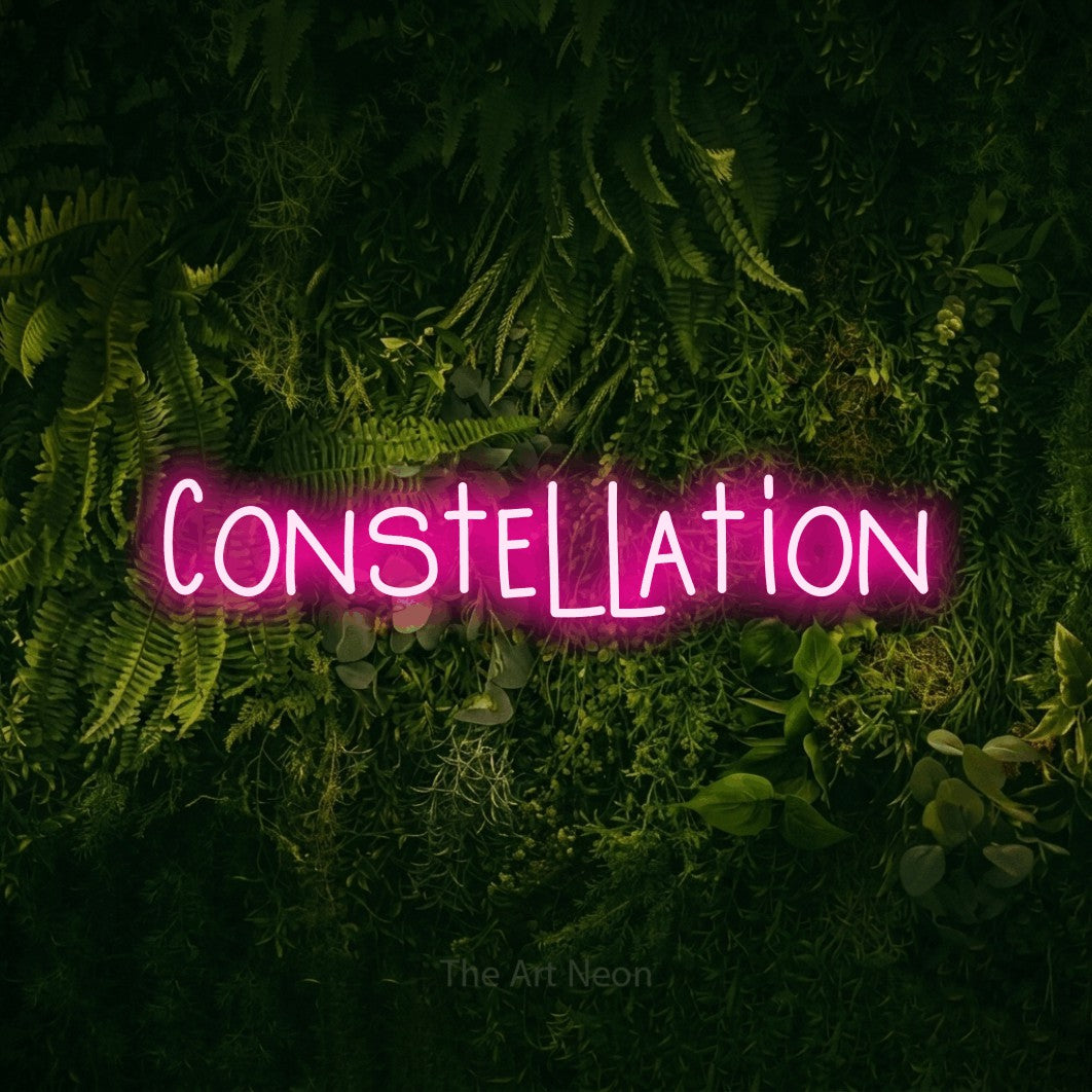 Enseigne néon à DEL à lumière rose vif, affichant « Constellation » sur un mur vert couvert de mousse