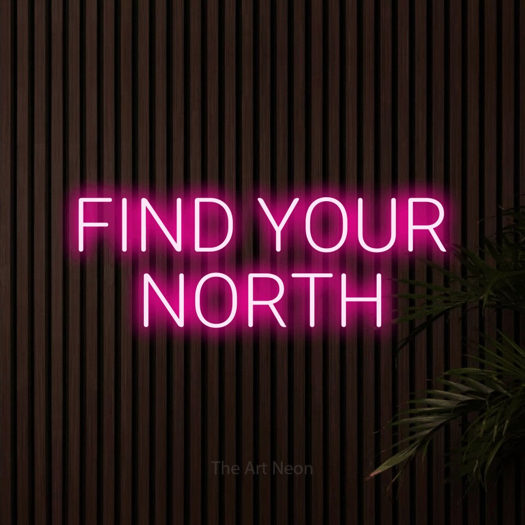 Hot pink LED neon sign reading "Find Your North" against dark wooden slats
