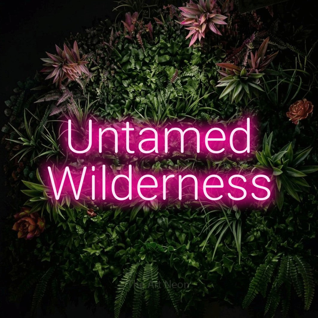 Hot pink LED neon sign reading "Untamed Wilderness" against a flowering garden wall