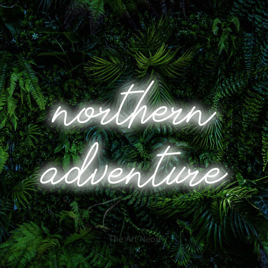 Cool white script-style LED neon sign reading "Northern Adventure" against a dense tropical foliage wall