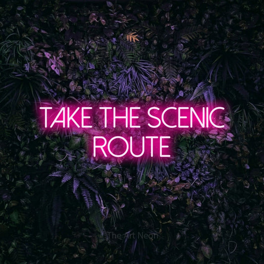Hot pink LED neon sign reading "Take the Scenic Route" against a purple floral wall