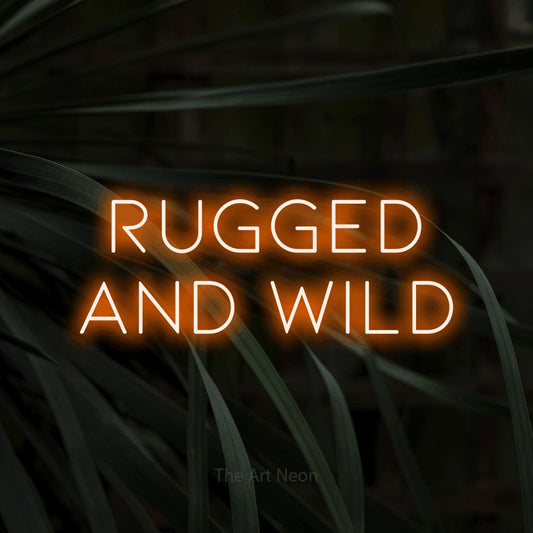 Orange LED neon sign reading "Rugged and Wild" against dark tropical leaves