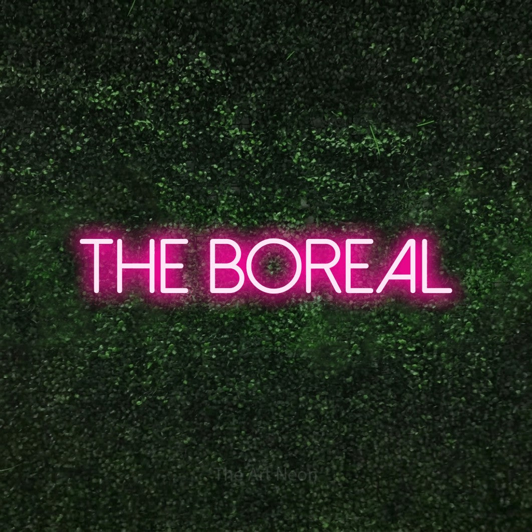Hot pink LED neon sign reading "The Boreal" against a textured green moss wall