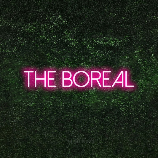 Hot pink LED neon sign reading "The Boreal" against a textured green moss wall
