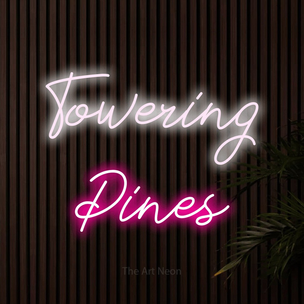 Hot pink and cool white script-style LED neon sign reading "Towering Pines" against dark wooden slats