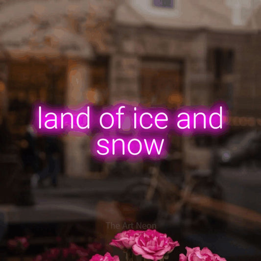 Pink LED neon sign reading "Land of Ice and Snow" in a softly blurred café interior