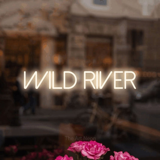 Warm white LED neon sign reading "Wild River" in a softly blurred café interior