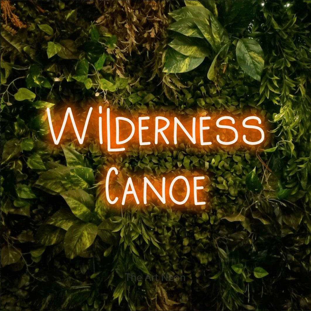 Orange LED neon sign reading "Wilderness Canoe" against a textured moss and foliage wall