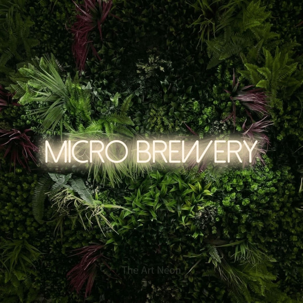 Warm white LED neon sign reading "Micro Brewery" against a lush garden wall with pink flowers