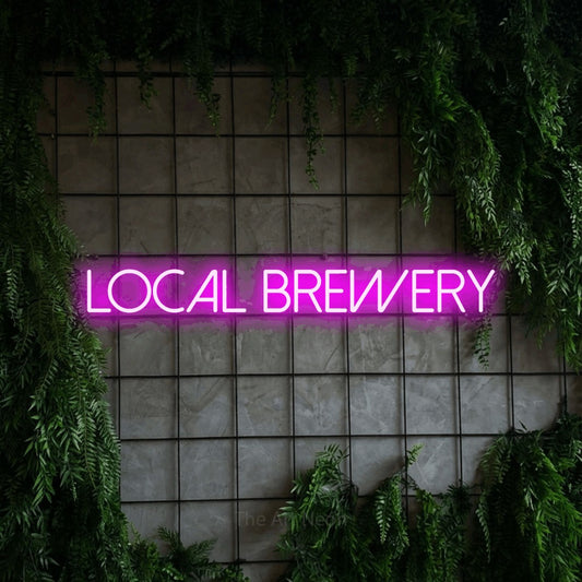 Pink LED neon sign reading "Local Brewery" against a green grid wall with foliage