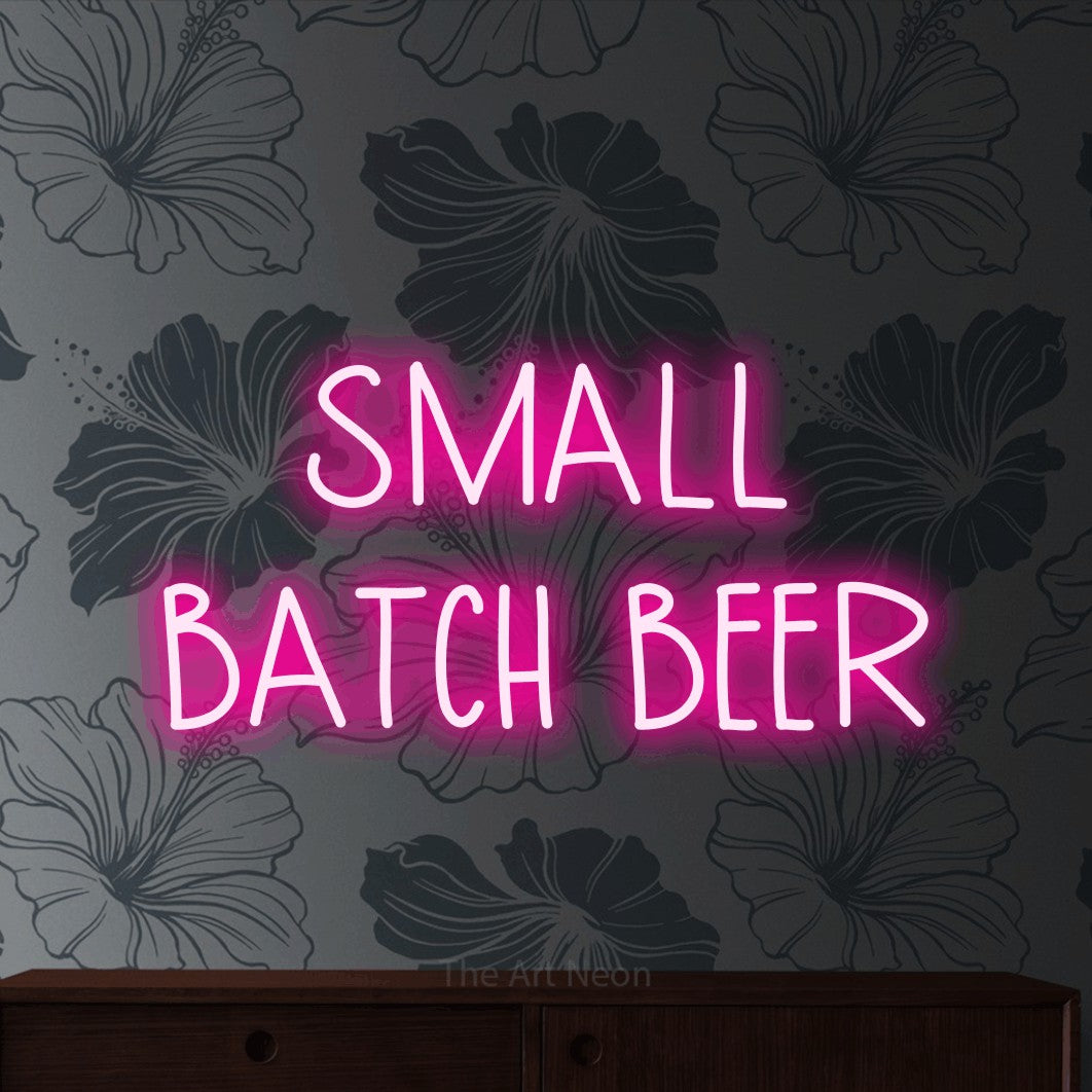 Hot pink LED neon sign reading "Small Batch Beer" against grey floral wallpaper