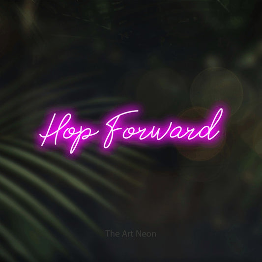Pink script-style LED neon sign reading "Hop Forward" against dark blurred palm leaves