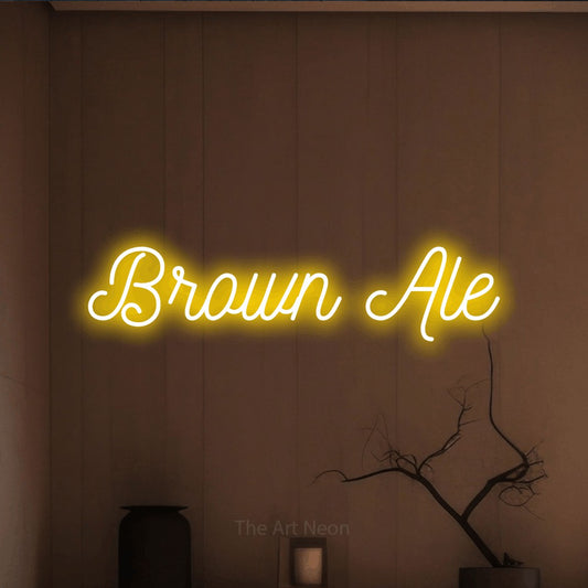 Yellow script-style LED neon sign reading "Brown Ale" against a warm brown wall