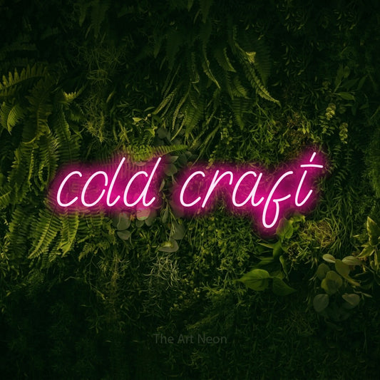 Hot pink LED neon sign reading "Cold Craft" against a moss-covered green wall