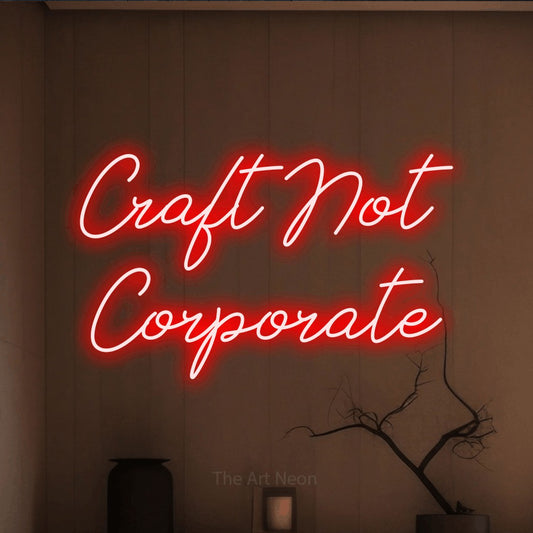 Red script-style LED neon sign reading "Craft Not Corporate" against a warm brown wall