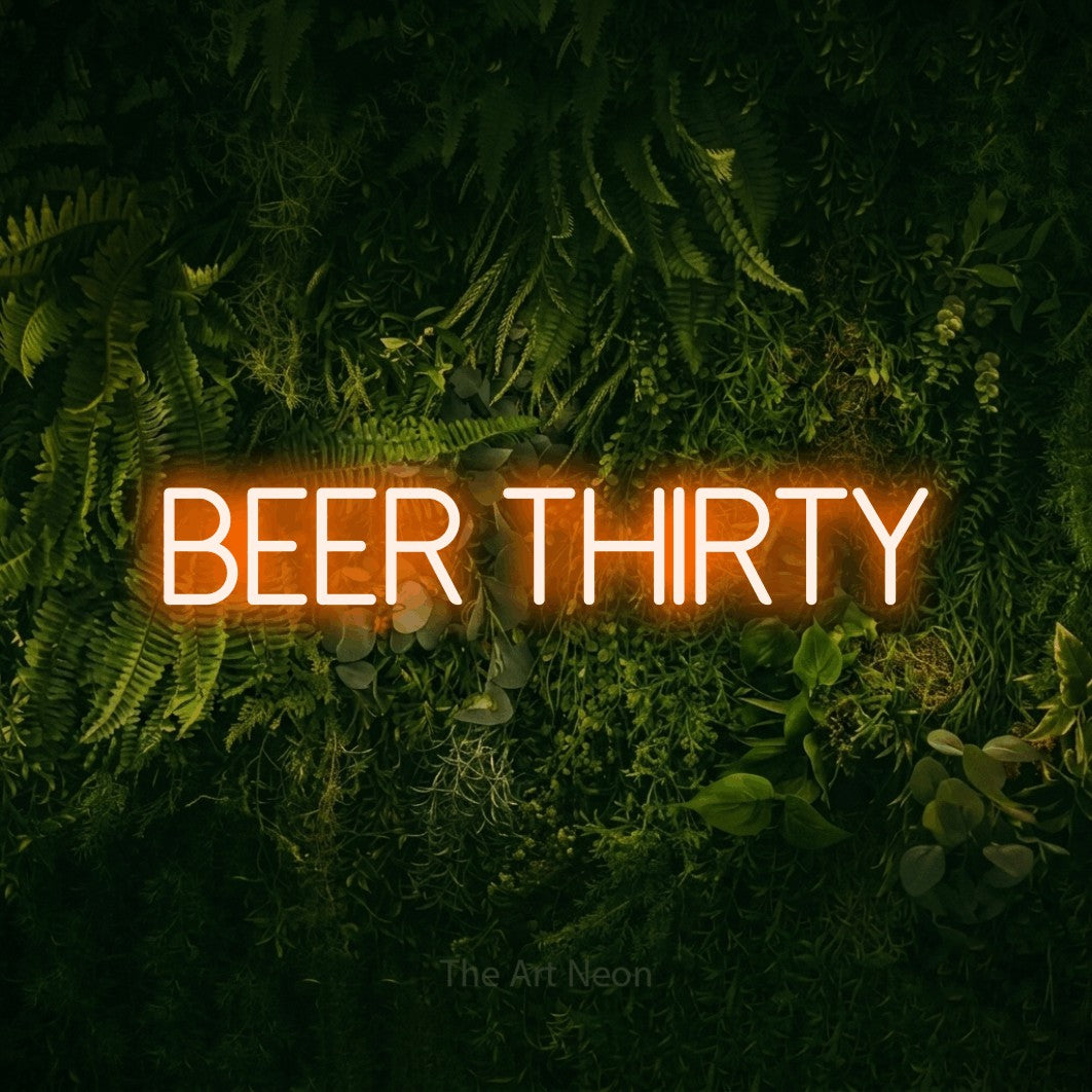 Orange LED neon sign reading "Beer Thirty" against a moss-covered green wall